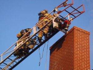 Firefighters on a Ladder at a Chimney